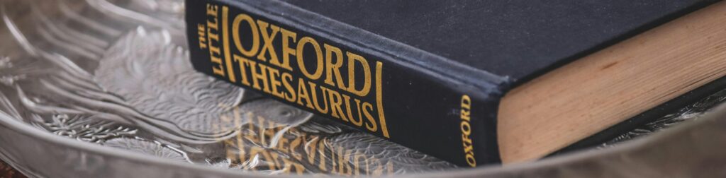 Elegant hardcover thesaurus with classic design on a textured glass plate.