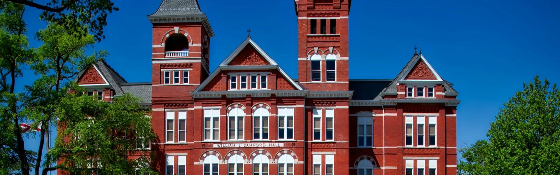 Front view of Samford Hall, Auburn University, with its iconic clock tower on a sunny day.